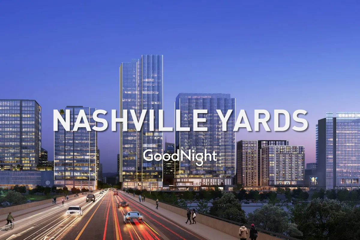 A bustling city exterior view featuring modern skyscrapers, well-lit roads, and visible pedestrian activity. The image captures the dynamic atmosphere of downtown Nashville, suggesting both business and leisure possibilities for guests.