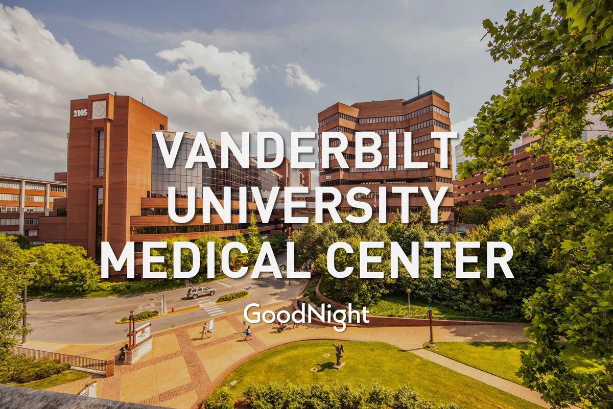 This image presents the Vanderbilt University Medical Center building surrounded by lush greenery and pedestrian walkways. The modern medical facility is the focal point, illustrating proximity to key medical institutions. The environment feels supportive and hopeful, with inviting outdoor spaces and pathways suggesting easy access and pleasant daily routines.